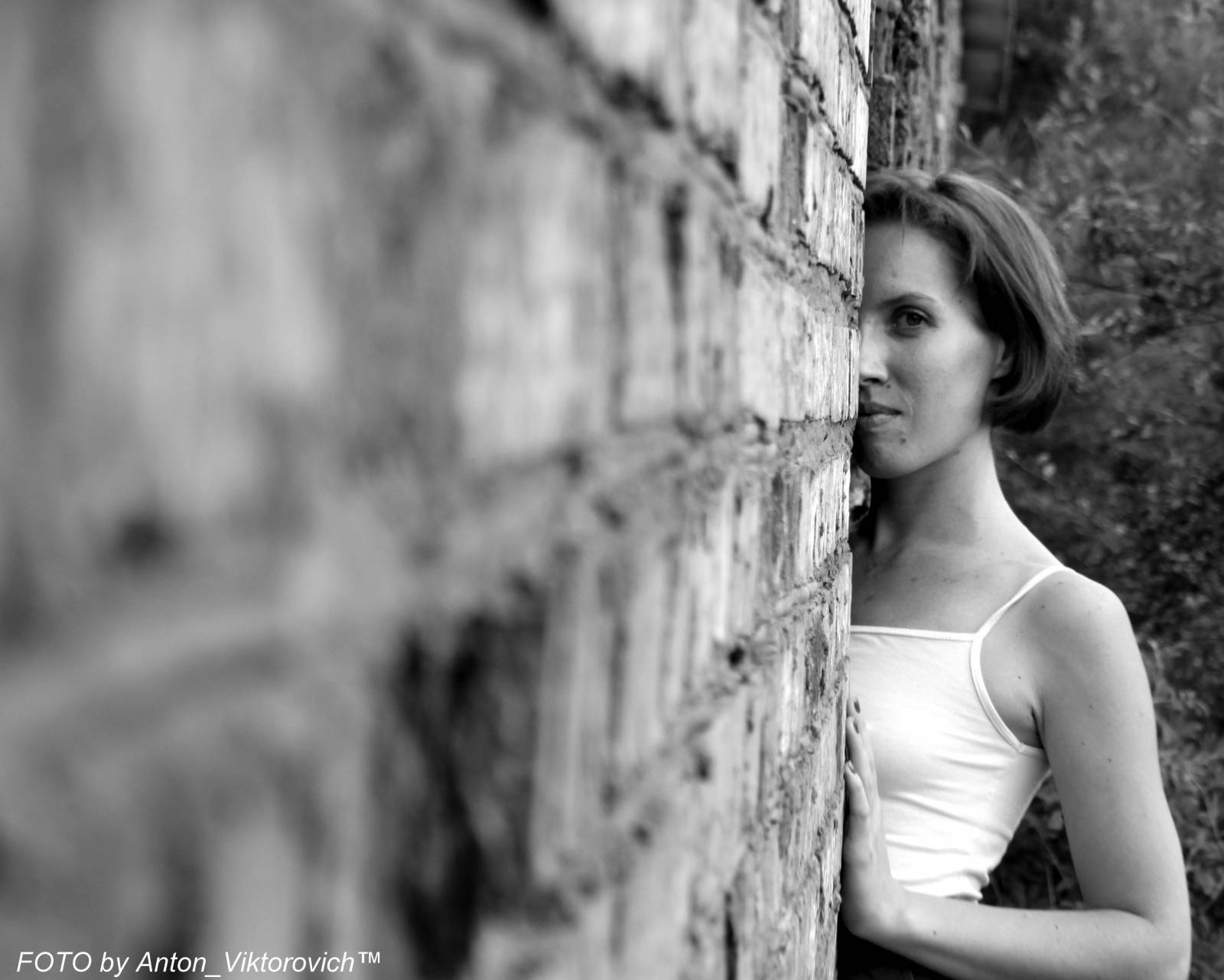 Молодая леди показывает стриптиз на фоне кирпичной стены - порно фото